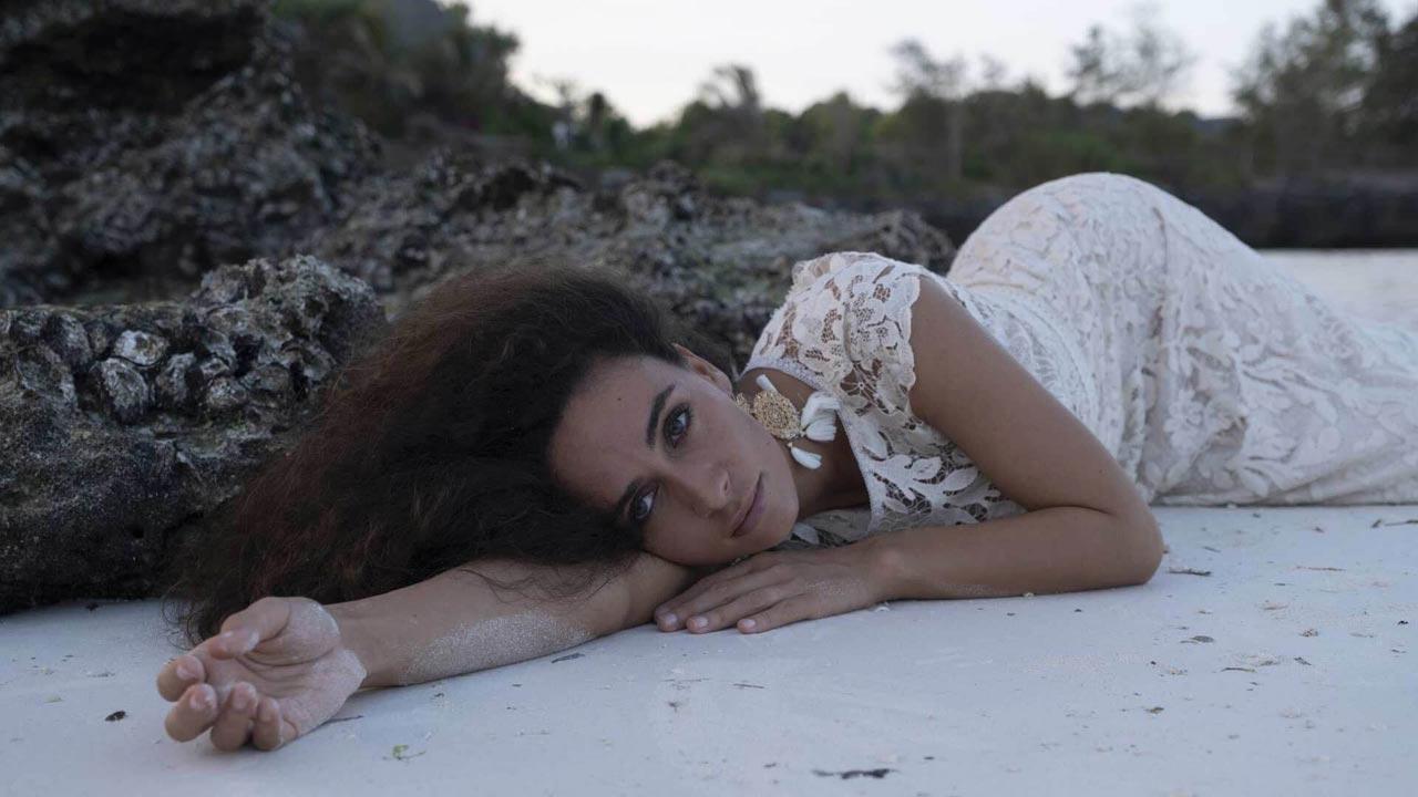 Brautkleider von Lilurose aus der Sansibar-Kollektion. Frau liegt am Strand in einem Brautkleid aus der Sansibar Lilurose Kollektion.